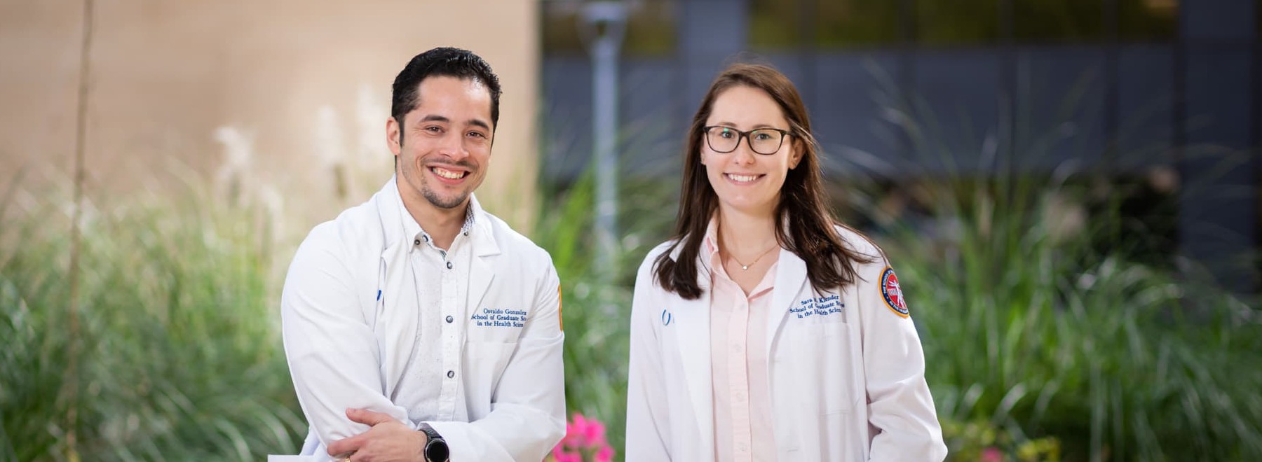 Male and female graduate students pose outside